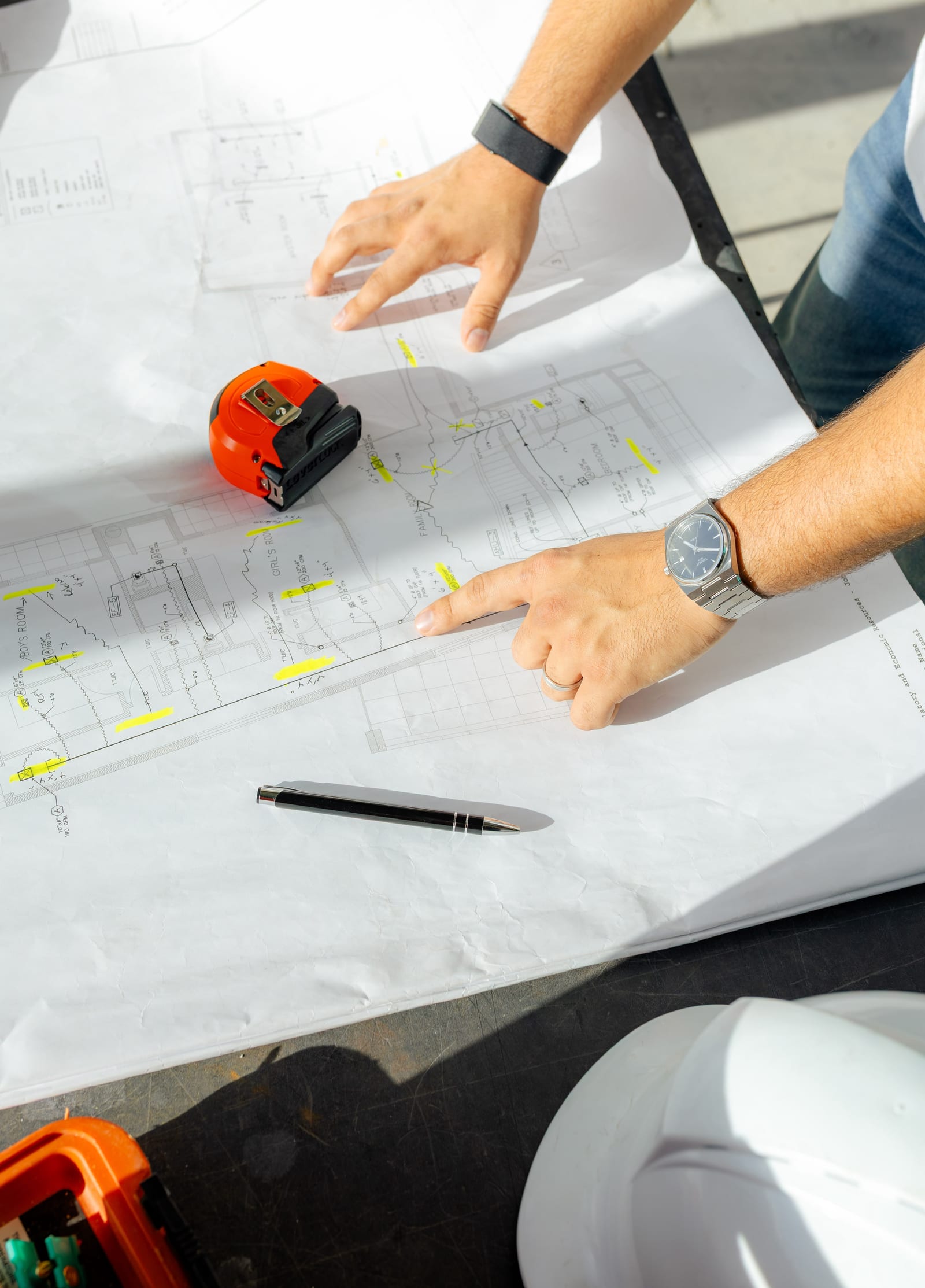 Close-up of architectural blueprints and measuring tape on site